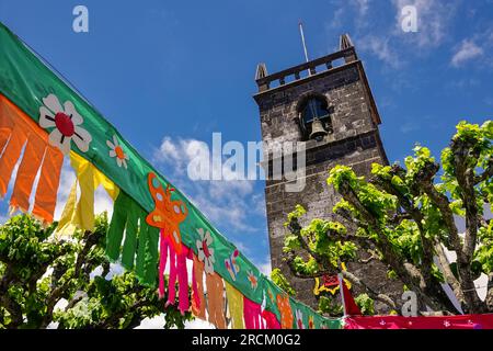 Festive pennants decorate the 16th century Igreja de São Miguel Arcanjo for the São João da Vila festival in the historic village of Vila Franca do Campo in Sao Miguel Island, Azores, Portugal. The village was established in the middle of the 15th century by Gonçalo Vaz Botelho. Stock Photo