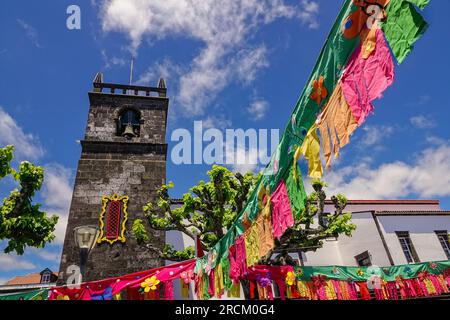 Festive pennants decorate the 16th century Igreja de São Miguel Arcanjo for the São João da Vila festival in the historic village of Vila Franca do Campo in Sao Miguel Island, Azores, Portugal. The village was established in the middle of the 15th century by Gonçalo Vaz Botelho. Stock Photo