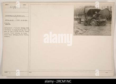 Men from the 82nd Division's Co. C, 307th Supply Train, are seen repairing a Packard truck in the muddy conditions of Vaux Sous Aubigny, Haute Marne, France during World War I. The image depicts the resourcefulness of the soldiers in maintaining and servicing their vehicles while on the road. Stock Photo