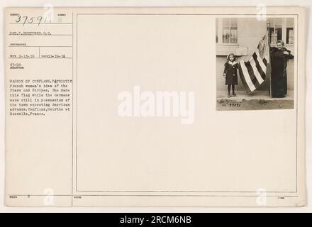 This image shows a French woman proudly displaying her handmade American flag in Conflans, Meurthe et Moselle, France. The flag was made during World War One while the town was occupied by the Germans, in anticipation of the American advance. Photographed on November 19, 1918, by Sergeant P. Fuettner. Stock Photo