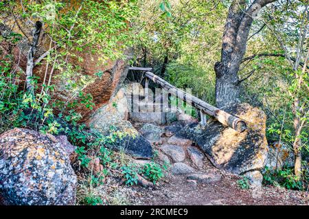 old rocky staircase with wooden balustrade for hikers and climbers in the mountain Stock Photo