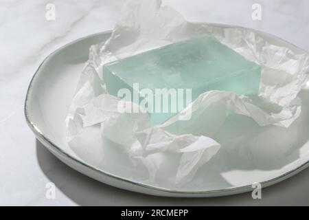 Natural bar soap for healthy skin and hair. Hydrating cleansing bar on crumpled package paper Stock Photo