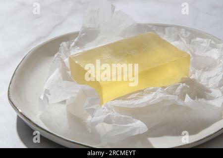 Natural bar soap for healthy skin and hair. Hydrating cleansing bar on crumpled package paper Stock Photo