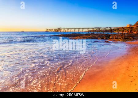 Sun lit sandy Middle camp beach at Catherine hill bay town on Pacific coast of Australia. Stock Photo
