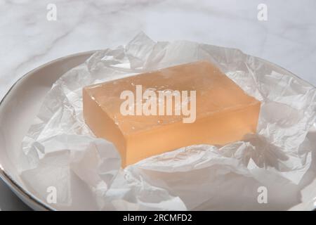 Natural bar soap for healthy skin and hair. Hydrating cleansing bar on crumpled package paper Stock Photo