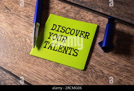 DISCOVER YOUR TALENTS - words on a pink piece of paper on a white notebook with glasses and pen. Stock Photo