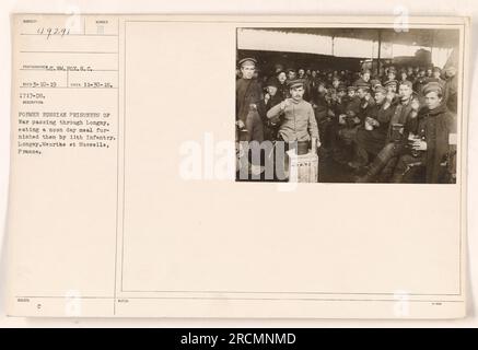 Former Russian Prisoners of War in Logway, France, enjoying a noon day meal provided by the 11th Infantry. This photograph was taken on November 30, 1918, by photographer M. Pox of the S.C. Reco. The image is part of a series documenting American military activities during World War One. Caption provided is factual and does not include any creative element. Stock Photo