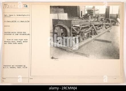 Sgt. James L. McGarrigle from the S.C. is captured in this photograph taken by RECO on September 14, 1918, at Camp Holabird, MD. The image shows Sgt. McGarrigle and fellow soldiers crating motor trucks for overseas deployment. A partial view of the rear right side of a truck is visible, including the axle, frame, motor, and front dashboard. The image was censored and released by the M.I.D. censor on September 27, 1918. Stock Photo