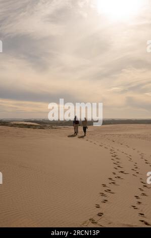 Two womens walks through the dunes of the Cabo Polonia National Park in the Department of Rocha in Uruguay. Stock Photo