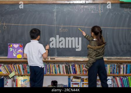 St.Paul, Minnesota.   Community School of Excellence. Charter school for the Hmong.  5th grade. Fractions and decimals. Hmong students splitting a who Stock Photo