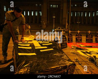 Lima, Peru. 15th July, 2023. People pasting papers with the names of the victims of the protests on a coffin when dozens gather to protest in front of the judiciary in a vigil as a prelude to the great national march called for next July 19th against President Dina Boluarte and the Congress.In previous riots, between December and March of this year, there were more than 50 deaths due to the use of excessive force by the police to control the protesters. Credit: Fotoholica Press Agency/Alamy Live News Stock Photo