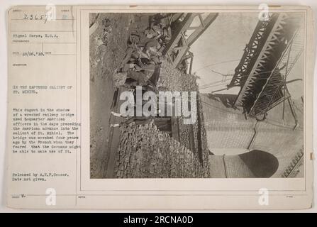 This image shows a dugout located beneath a wrecked railway bridge in the captured salient of St. Mihiel during World War I. The dugout was used to house American officers before their advance into the salient. The bridge was destroyed by the French four years earlier to prevent the Germans from utilizing it. This photograph was released by the A.E.F. Censor, and the exact date is unknown. (50 words) Stock Photo