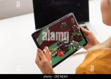 Man betting on sports using laptop at table, closeup. Bookmaker website on screen Stock Photo