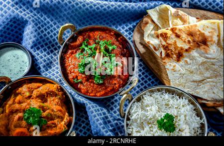 Hot madras paneer and vegetable masala with basmati rice served in original indian karahi pots. Stock Photo