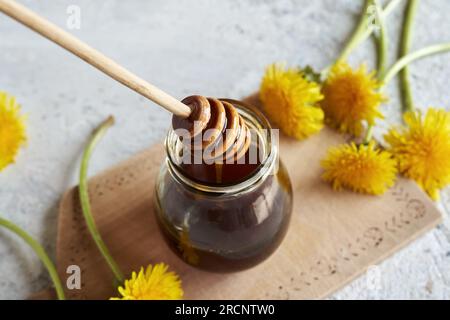 Dandelion honey in a glass jar with a dipper Stock Photo