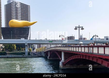 Tokyo, Japan-April 2023; Side view of the Azuma-bashi bridge over the Sumida River and in the background the Asahi Beer Hall with on top the Asahi Fla Stock Photo