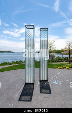Greenwich, CT, USA-May 2022;  View of two glass towers of the September 11 Memorial in Cos Cob Memorial Park throwing shadow on ground against backdro Stock Photo