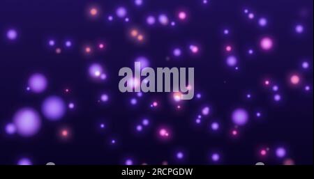 Blue and purple sparkling particles swirling in the air on a blue background. Stock Photo