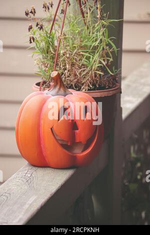 Ceramic pumpkin decor is on wooden plank for Halloween background. Stock Photo