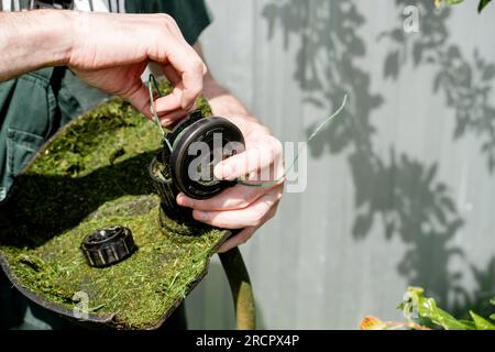 man cleaning the lawn mower from the grass close-up Stock Photo