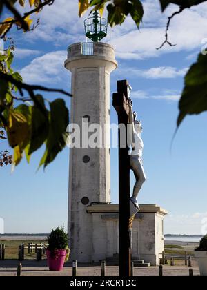 Lighthouse and calvary among leaves at Cayeux sur Mer, a resort town in the Somme department in Hauts-de-France in northern France. Stock Photo