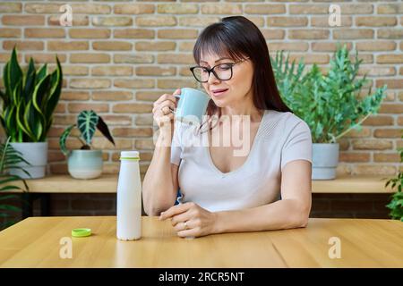 Middle aged woman drinking fermented milk product from bottle Stock Photo