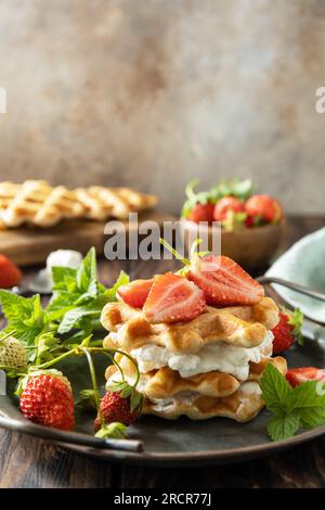 Belgian waffles with fresh berrie strawberries and ricotta cheese for breakfast on a rustic table. Copy space. Stock Photo