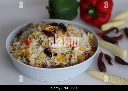 Chilly garlic vegetable rice. Mildly spiced garlic flavored basmati rice with sauteed bell pepper and baby corn. Shot on white background along with r Stock Photo
