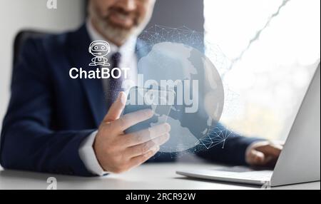 Middle aged businessman wearing working on laptop, smartphone, using chatbot Stock Photo
