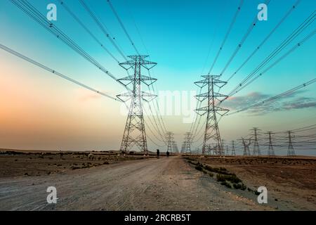High Voltage an electric tower in sunset time near Al Hofuf Desert - Saudi Arabia. Stock Photo