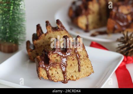 Slices of flower shaped whole wheat plantain cake topped with chocolate sauce. Cake with whole wheat flour and pureed ripe plantain. Baked in a flower Stock Photo