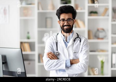 Handsome middle eastern family doctor posing at office at clinic Stock Photo