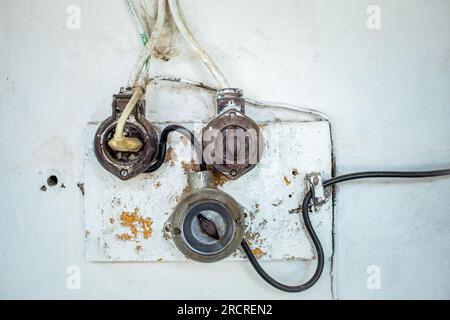 Vintage old light switch on a wooden frame with scratches and dust. Stock Photo