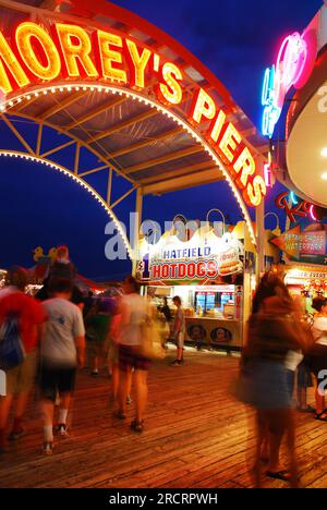 A crowd scurries on the boardwalk outside of an amusement area on the pier in Wildwood, New Jersey Stock Photo