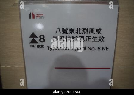 Hong Kong, China. 17th July, 2023. A notice writes 'Typhoon Signal No.8' is sticked on the wall. On July 16th and 17th, Hong Kong brace itself for the arrival of Typhoon Talim, as the city is issued the T8 warning signal by the Hong Kong Observatory for the first time in 2023. As the storm approaches, the effects are felt in various parts of the city, including Tsim Sha Tsui and Heng Fa Chuen, where residents venture out to experience the might of the typhoon. Credit: SOPA Images Limited/Alamy Live News Stock Photo