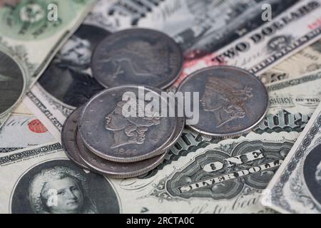 Old west US banknotes and silver certificates with silver dollar coins background Stock Photo