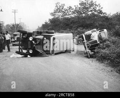 Long Island, New York:  c. 1937 Two overturned vehicles after an accident between a truck and an automobile on a Long Island highway. Stock Photo