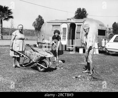 Brawley, California:  c. 1961 Three women cleaning up the area outside their trailer at Cattle Call Grounds. Stock Photo