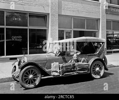Portland, Oregon: c. 1919 Four women sitting in an Oldsmobile with their luggage on the running board and an Airedale dog laying on top of it. Stock Photo