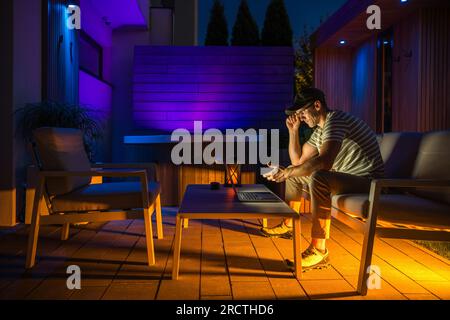 Remotely Working From a Modern Backyard Garden Caucasian Man in His 40s Stock Photo