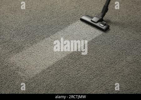 Vacuuming grey carpet. Clean area after using device. Space for text Stock Photo