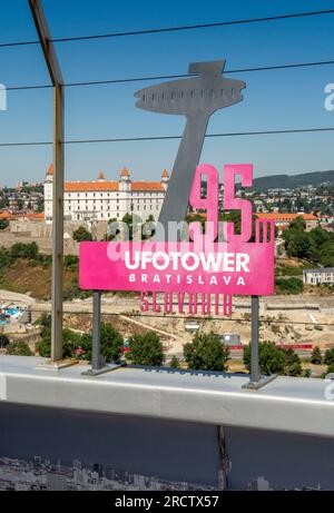 Bratislava, Slovakia - July, 15, 2023 : UFO TOWER sign with Bratislava castle in the background. Stock Photo