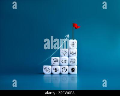 Rising up arrow on red flag on the top of growth graph steps, white blocks with business strategy management symbols elements on blue background. Goal Stock Photo
