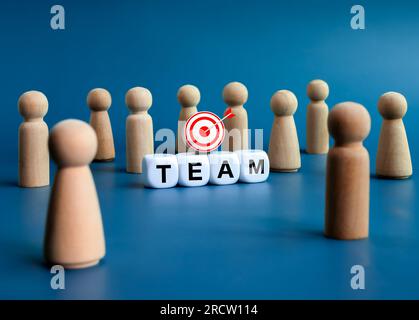 Team, teamwork, leadership and family business concepts. Words "TEAM", text on white cube blocks with 3d target icon and many wooden figures, people s Stock Photo