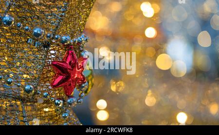 Hanging red star with light bokeh background. Copy space. Stock Photo