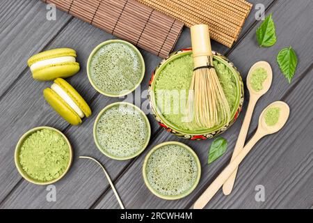 https://l450v.alamy.com/450v/2rcwh4m/bamboo-whisk-in-bowl-with-matcha-powder-matcha-green-tea-macaroni-cakes-and-wooden-spoons-on-table-flat-lay-dark-wooden-background-2rcwh4m.jpg