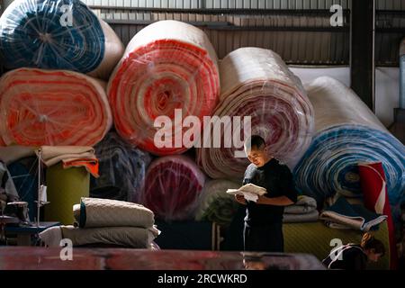 Kunming, China's Yunnan Province. 7th Apr, 2023. Mao Guangyou ponders on the design of 'Truck Baby' mattress at the factory in Fuyuan County of Qujing City, southwest China's Yunnan Province, April 7, 2023. Mao Guangyou dedicated countless nights over the past decade to navigating his truck through the lofty mountains of China. When feeling sleepy, he would pause along his journey and find solace and respite under the vast expanse of the starry sky.TO GO WITH 'Across China: Former truck driver dreams big on road to restful journey' Credit: Hu Chao/Xinhua/Alamy Live News Stock Photo