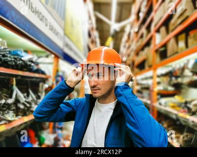 a man measures a helmet in a store Stock Photo