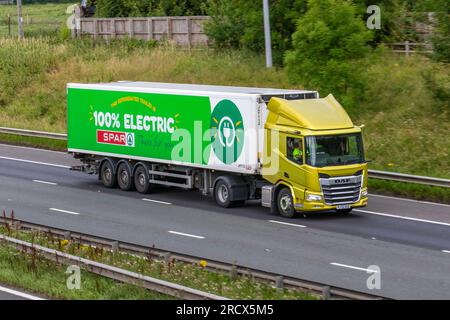 2022 Yellow 100% Electric DAF CF Electric,  two-axle tractor unit XO Spar supermarket pure-electric lorry. A 19-tonne Electra e-Cargo refrigerated rigid vehicle; travelling at speed on the M6 motorway in Greater Manchester, UK Stock Photo