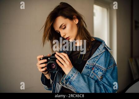 Youg female photographer holding camera. Stock Photo